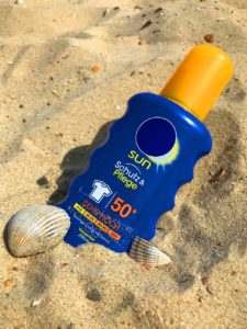 sunscreen bottle in the sand