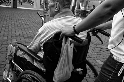 man in a wheel chair being pushed